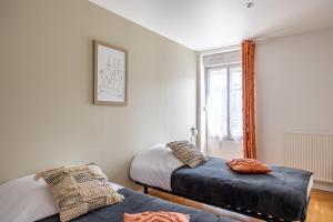 1 dormitorio con 2 camas y ventana en La Mousson - Centre-Ville - Arrivée Autonome en Annonay