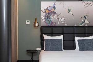 a bedroom with a bed with a black headboard and a painting at Hotel2Stay in Amsterdam