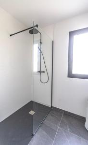 a glass shower in a white room with a window at La Marssacoise in Marssac-sur-Tarn