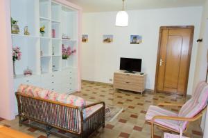 a living room with a couch and a chair and a television at Agrigento CityCenter in Agrigento