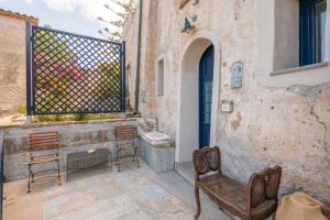 a patio with two chairs and a table and a window at Monolocale Sirena vista mare in San Marco di Castellabate +3 photos
