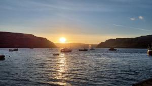 a group of boats in the water at sunset at Pink House Skye in Portree