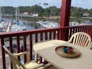 einen Tisch und Stühle auf einem Balkon mit Yachthafen in der Unterkunft Appartement Capbreton, 2 pièces, 4 personnes - FR-1-413-101 in Capbreton