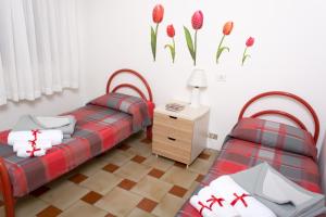 アグリジェントにあるAgrigento CityCenterの花が飾られた壁の客室内のベッド2台