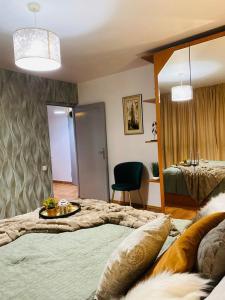 Un dormitorio con una cama grande y una mesa. en City Center Green Apartment, en Bucarest