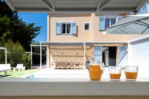 two glasses of orange juice sitting on a table in front of a house at Villa Acacias - Au coeur de Saint-Tropez in Saint-Tropez