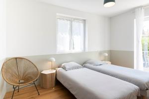 een kamer met 2 bedden en een stoel. bij Villa Acacias - Au coeur de Saint-Tropez in Saint-Tropez