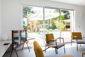 サントロペにあるVilla Acacias - Au coeur de Saint-Tropezの椅子とテーブル(パラソル付)