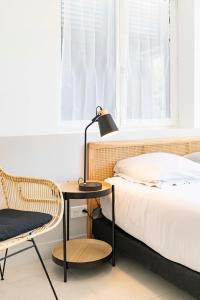 a bedroom with a bed and a table and a chair at Villa Acacias - Au coeur de Saint-Tropez in Saint-Tropez