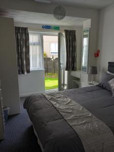 a bedroom with a large bed and a window at Carron House Holiday Apartments in Skegness