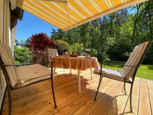 einen Tisch und zwei Stühle auf einer Terrasse mit einem Sonnenschirm in der Unterkunft Ferienwohnung Heide-Tukkul in Hermannsburg