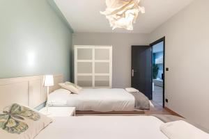 a bedroom with two beds and a chandelier at Bilbao Urban City in Bilbao