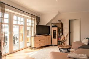 a living room with a tv on a wooden dresser at Ferienwohnung Lüchtkieker Wangerooge in Wangerooge