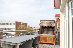 a balcony with a table and a chair on it at Ferienwohnung Lüchtkieker Wangerooge in Wangerooge