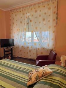 1 dormitorio con 1 cama y ventana con silla en Vicino a tutto, en Vercelli