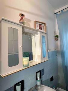 La salle de bains est pourvue d'un lavabo blanc et d'un miroir. dans l'établissement Vicino a tutto, à Verceil