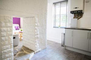 a kitchen with a stone wall in the middle of a room at Purple Blossom, cosy 2 bed apartment, near Didsbury, free parking in Manchester