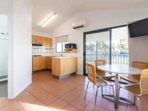 cocina y comedor con mesa y sillas en NRMA Bowen Beachfront Holiday Park en Bowen