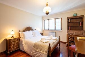 una camera con letto, scrivania e finestra di casabraga.207 - Villa with Pool Bom Jesus a Braga