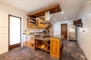 a kitchen with wooden cabinets and a counter top at casabraga.207 - Villa with Pool Bom Jesus in Braga