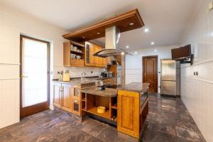 una cucina con mobili in legno e un piano di lavoro di casabraga.207 - Villa with Pool Bom Jesus a Braga