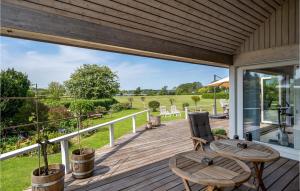 a wooden deck with two tables and chairs on it at 2 Bedroom Amazing Home In Roskilde in Roskilde