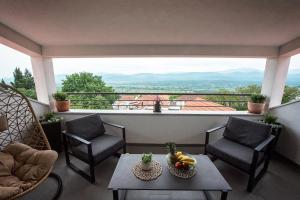 a balcony with a table and chairs and a view at Apartman I & J in Imotski