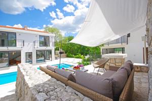 een villa met een zwembad en een patio bij Villa Sokol with tennis court, heating pool, gym and sauna in Sokoli