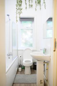 a bathroom with a white toilet and a sink at Purple Blossom, cosy 2 bed apartment, near Didsbury, free parking in Manchester