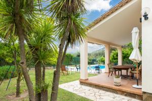 een patio met palmbomen en een tafel bij Villa Pelach in Calonge