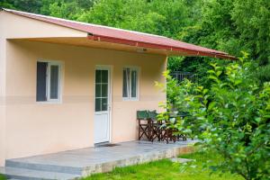 une petite maison avec une terrasse couverte et 2 chaises dans l'établissement Vikendica Luka, 