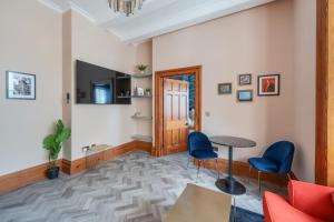 The Governance Apartments في ويندرمير: غرفة معيشة مع طاولة وكراسي زرقاء
