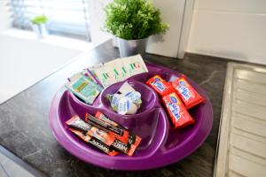 a purple plate with toothbrushes toothpaste and other items on it at Purple Blossom, cosy 2 bed apartment, near Didsbury, free parking in Manchester