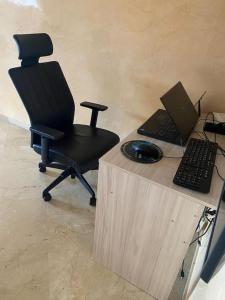 uma secretária com uma cadeira e um computador portátil em Appart spacieux et calme à 2 pas du TGV Agdal em Rabat