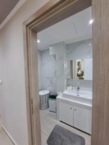 a bathroom with a sink and a large mirror at Elegance apartment in Paleo Tsifliki +32 photos