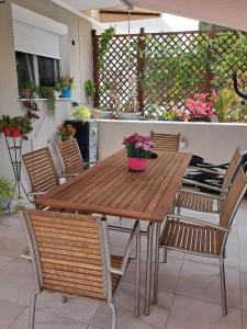 a wooden table and chairs on a patio at Elegance apartment in Paleo Tsifliki