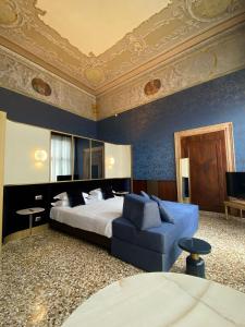 a bedroom with a large bed and a blue couch at Ca' Vendramin Zago in Venice +47 photos