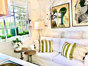 a living room with a white couch and windows at Cute tiny house in Rafina