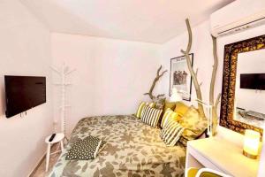1 dormitorio con cama, espejo y TV en Cute little house en Rafína