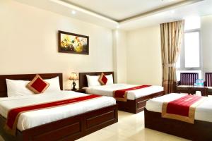 Habitación de hotel con 2 camas y ventana en Dattravi Hostel, en Da Nang
