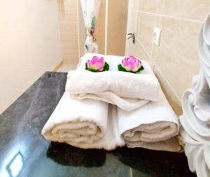 a bathroom with white towels and pink flowers on them at Adeje House 2 bedrooms, Wifi Free in Adeje