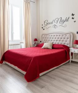 una camera con un letto rosso e una coperta rossa di Sapore di mare 5 Terre Affittacamere a La Spezia