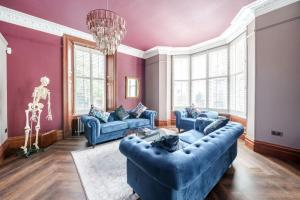 a living room with purple walls and blue couches at The Governance Apartments in Windermere