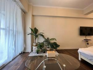 a living room with a glass table and potted plants at 海沐輕旅 Sea Mu Kenting in Nanwan