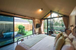 um quarto com uma cama grande e uma janela grande em Thara Dara Khaoyai em Ban Tha Maprang