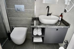 ReynaBe Boutique Hotel في ديكيلي: حمام مع حوض أبيض ومرحاض