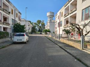 um carro branco estacionado ao lado de uma rua em Venere Home em Metaponto