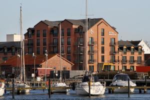 a group of boats docked in a marina with buildings at Hafenhotel Meereszeiten in Heiligenhafen