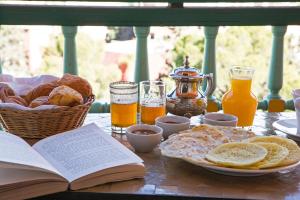 - une table avec un livre ouvert, du pain et du jus d'orange dans l'établissement Es Saadi Marrakech Resort - Hotel, à Marrakech