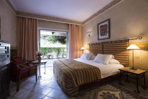 - une chambre avec un grand lit et une fenêtre dans l'établissement Es Saadi Marrakech Resort - Hotel, à Marrakech
